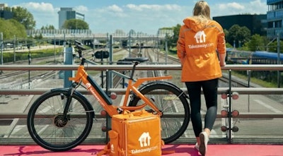 Woman standing alongside a bike
