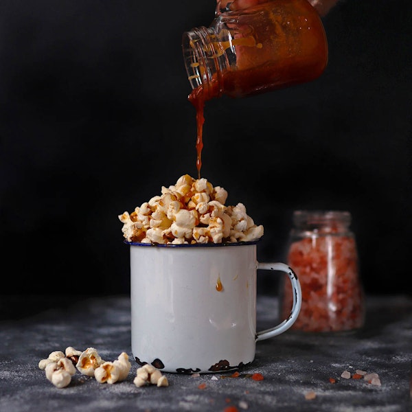 Caramel being poured over popcorn