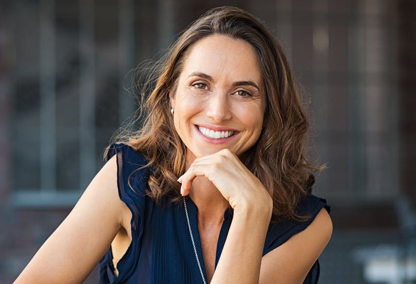 Woman with her hand to her chin, smiling
