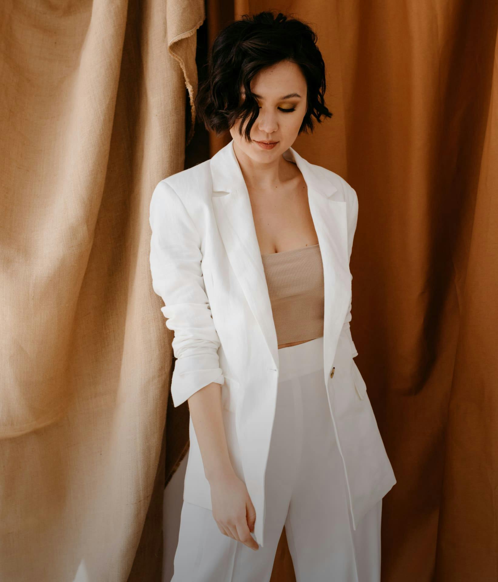 Woman posing in front of a fabric background.