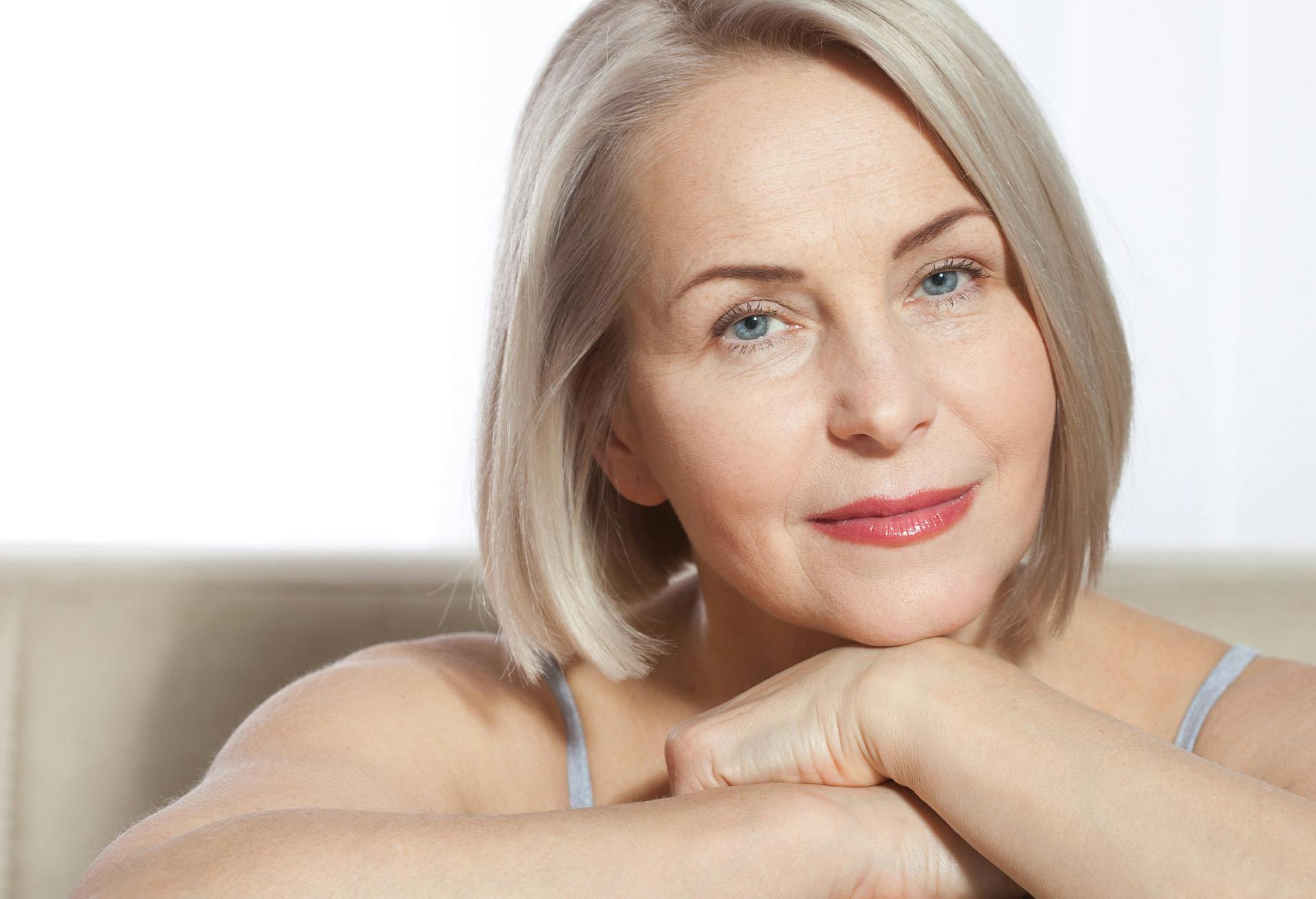 Woman smiling with her chin on her hands