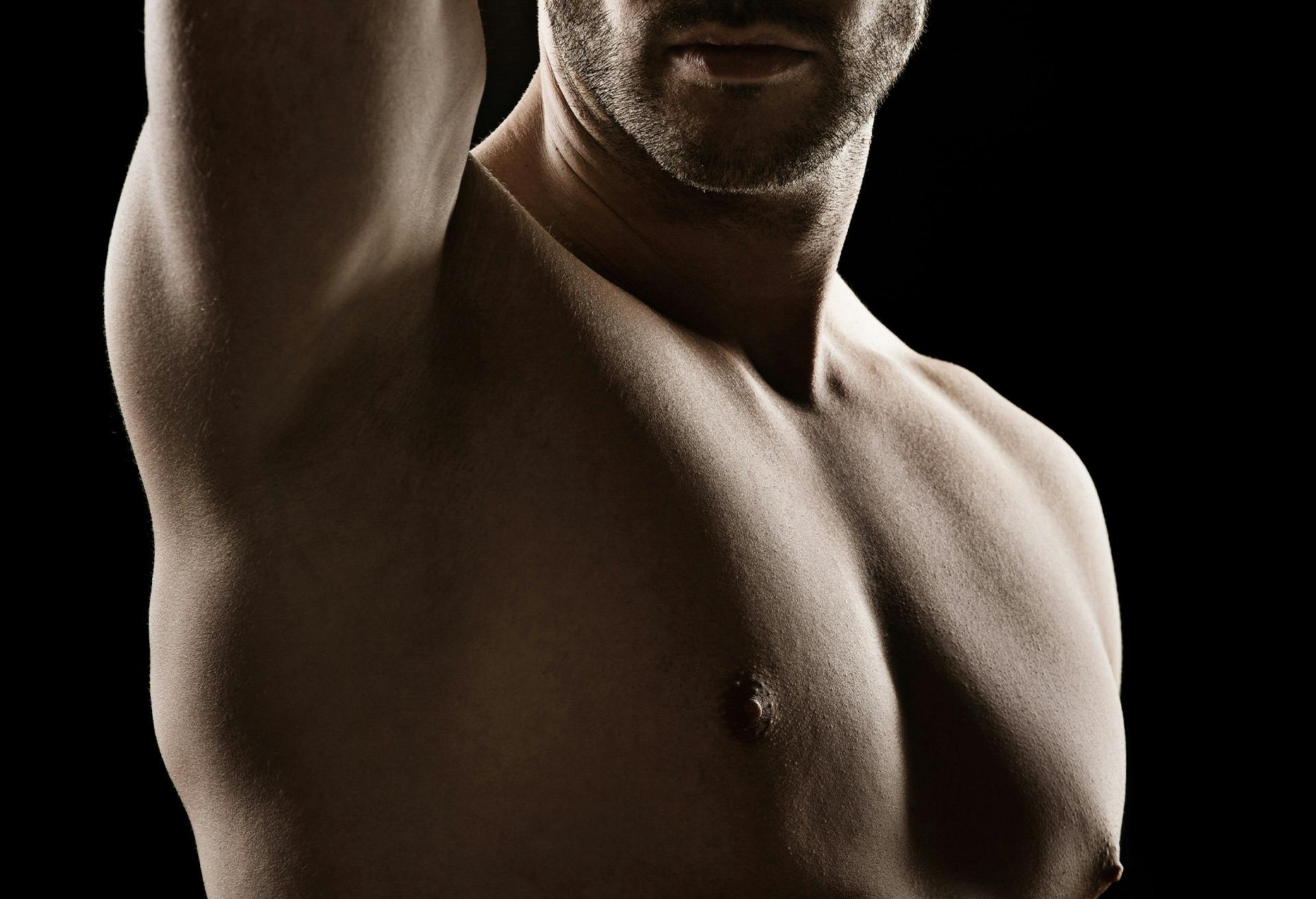 Shirtless man in shadow.
