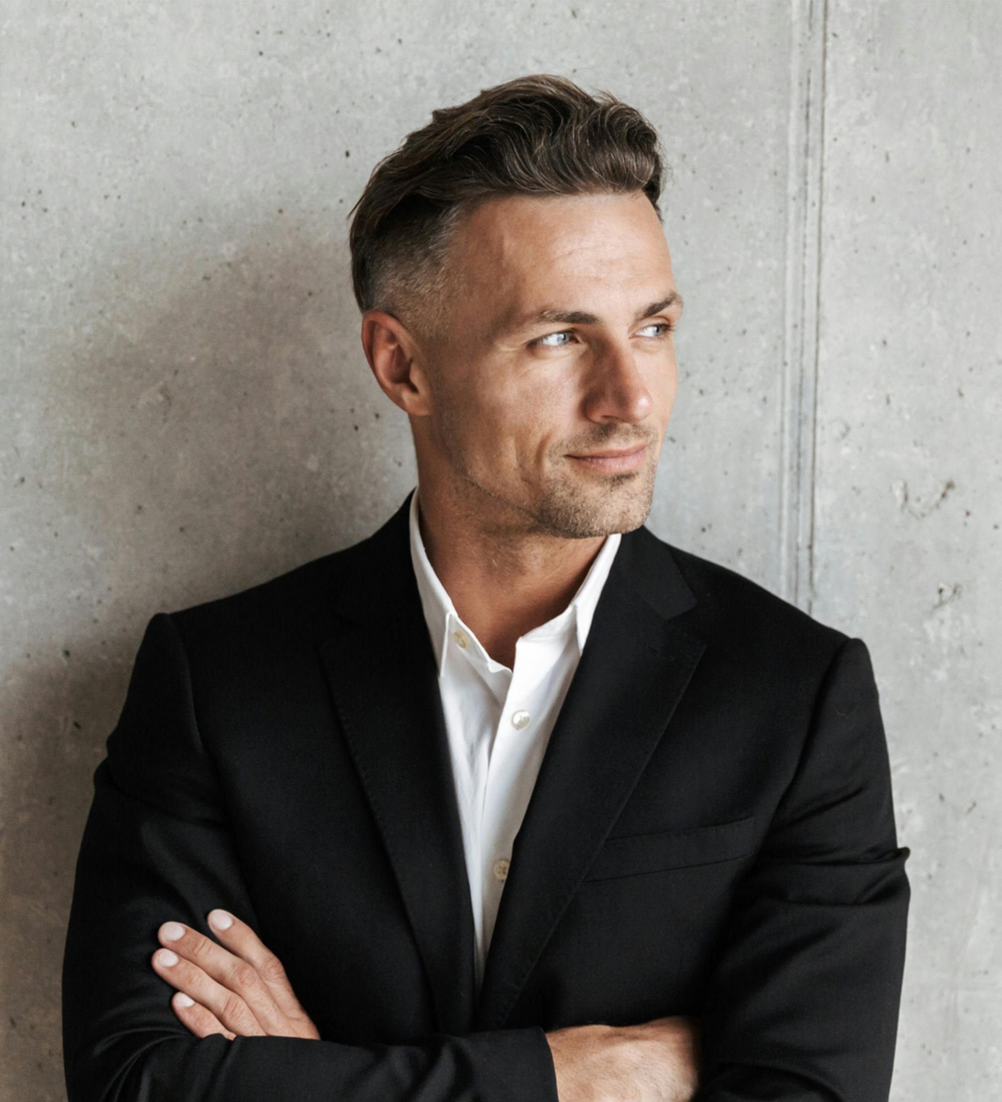 Man posing in a suit without a tie.