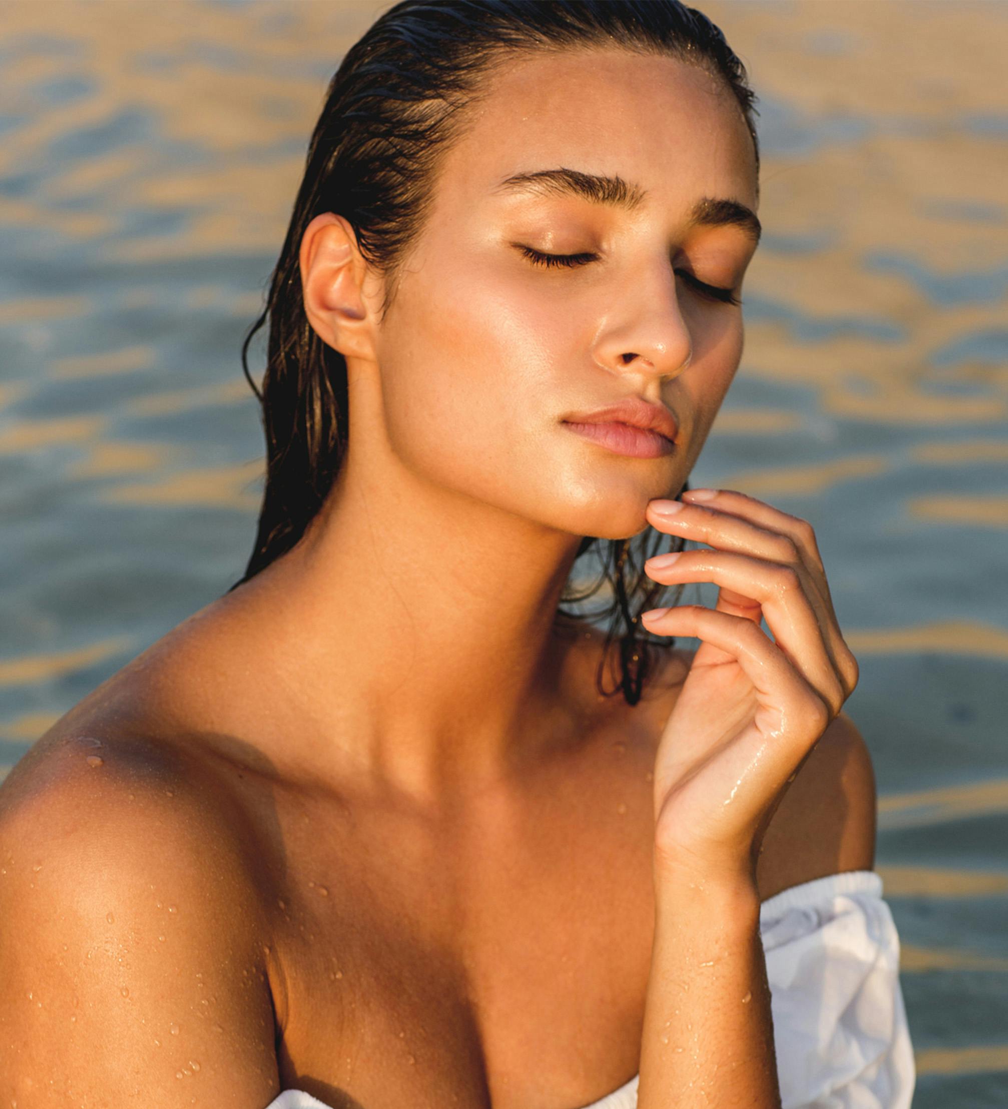 Woman on the beach with her eyes closed