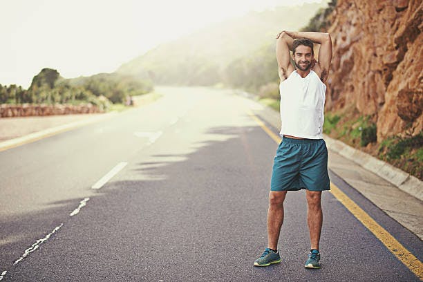 Man stretching on a road