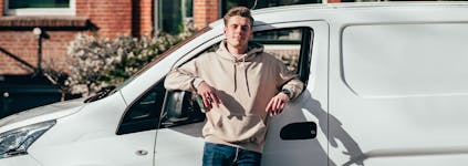 Bezorger die voor de bus staat