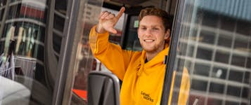 Buschauffeur die zwaait vannuit de bus