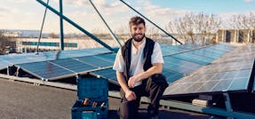 A electrician standing on the roof with solar panels