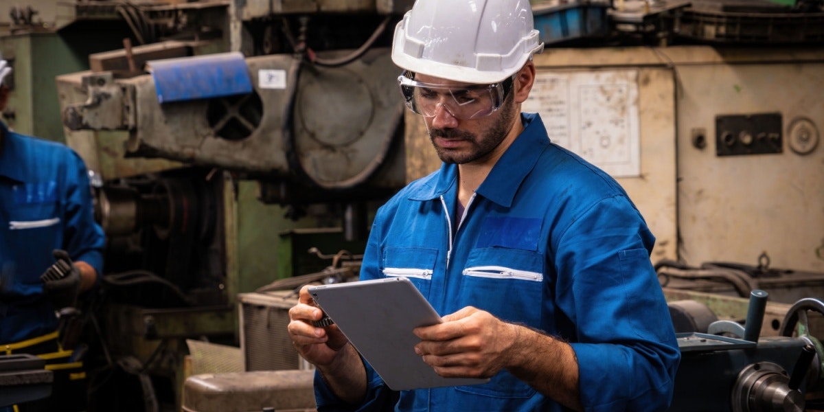 Man op werkplaats met helm