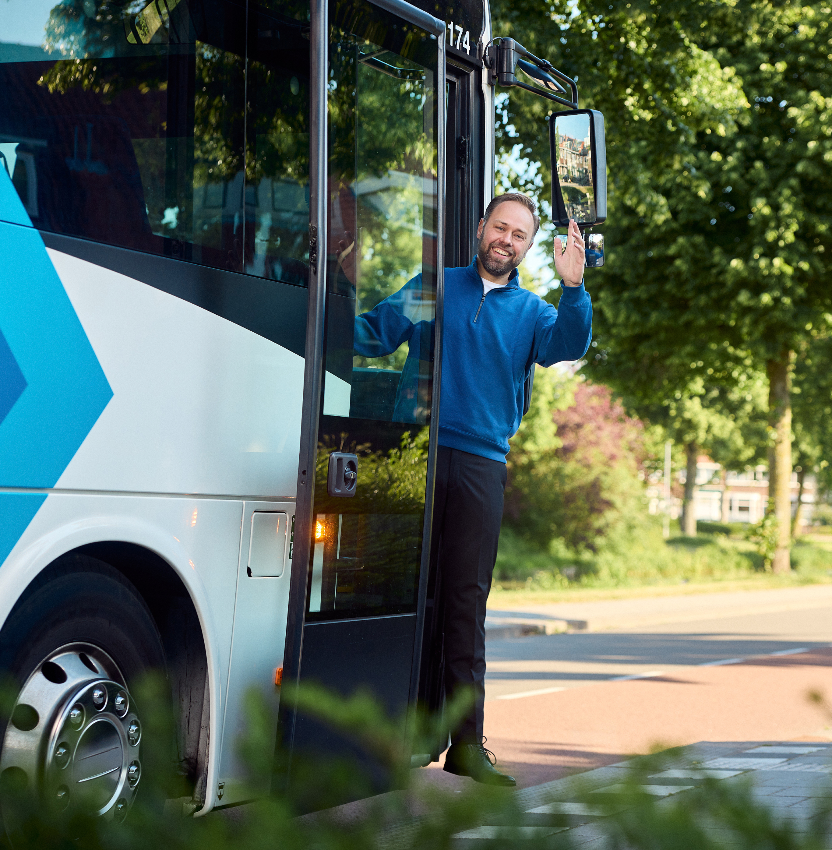 Buschauffeur zwaait vanuit busingang