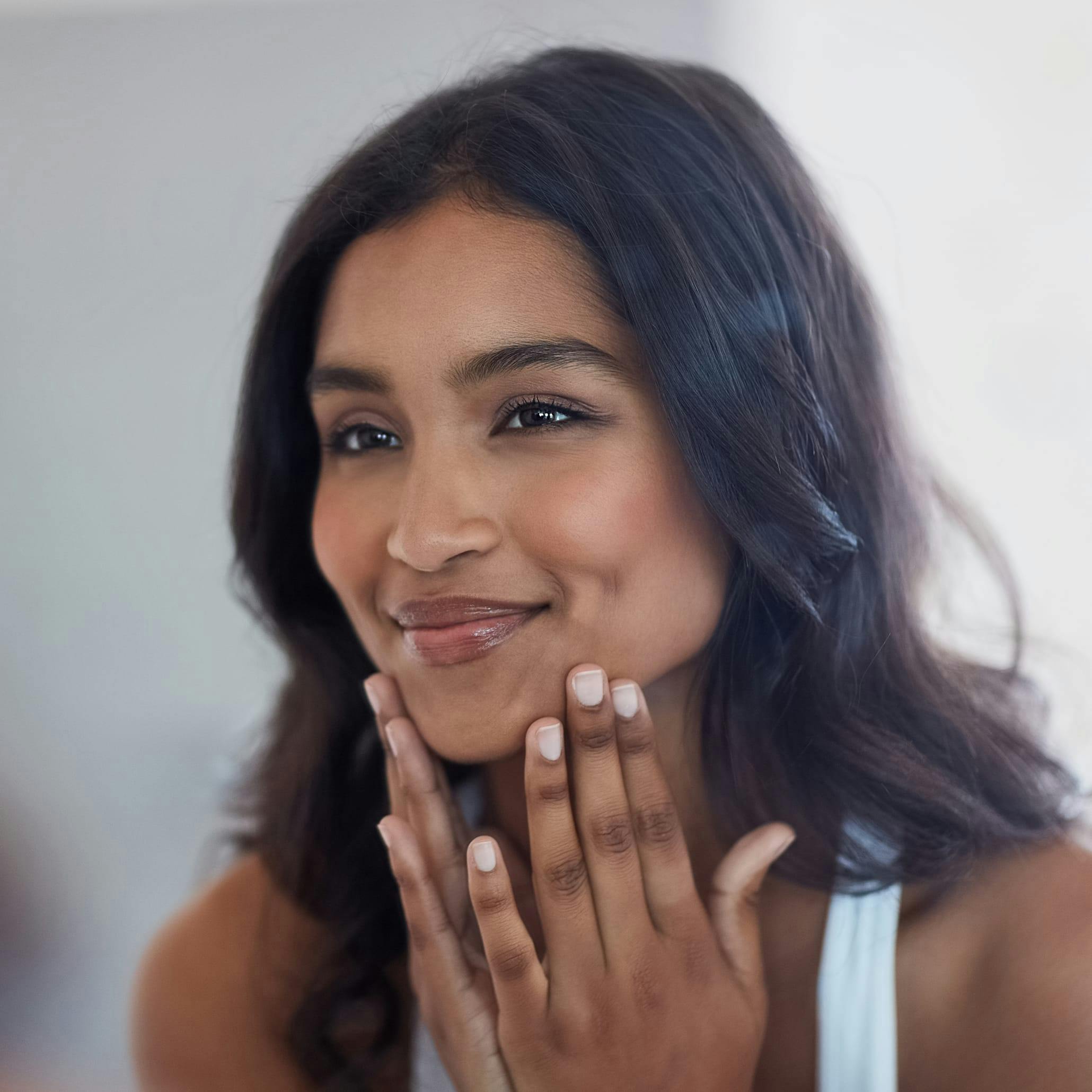 Woman looking at herself in the mirror smiling
