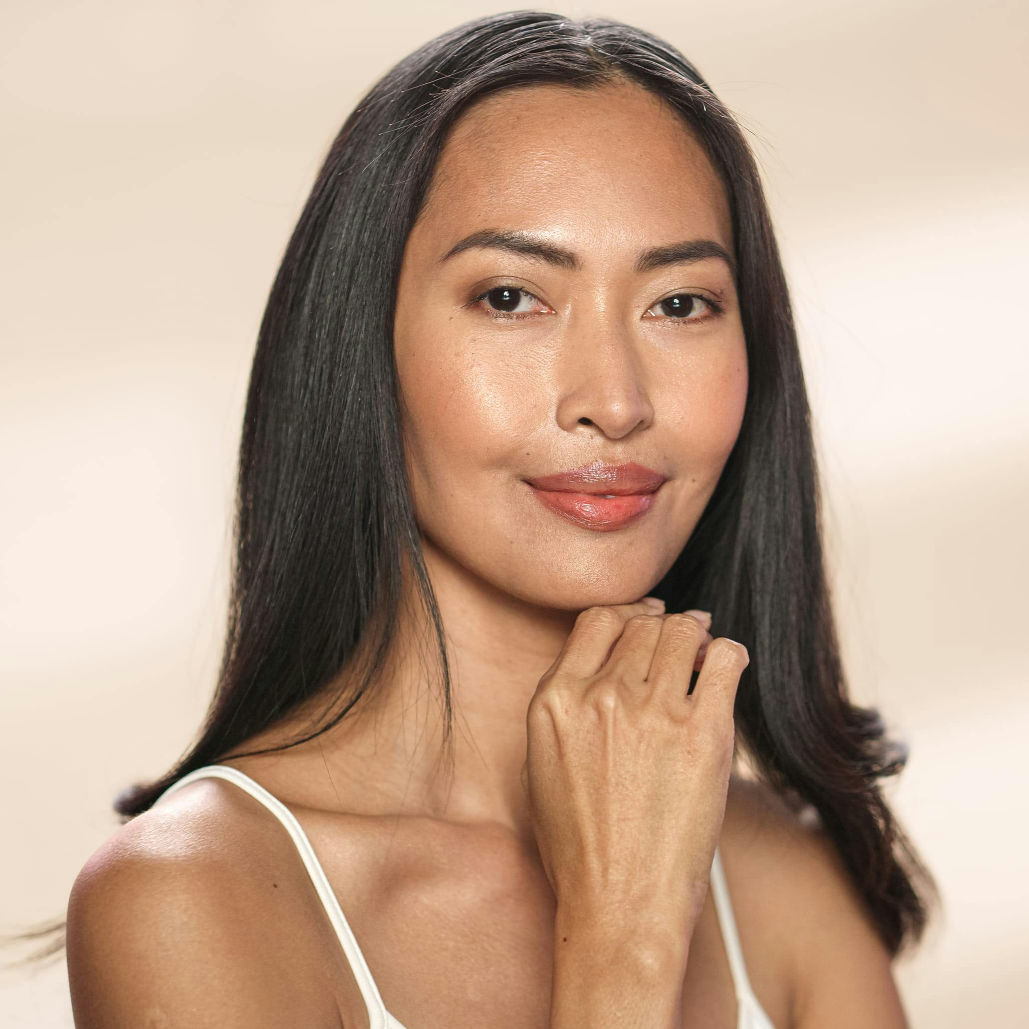 Woman with long dark hair smirking