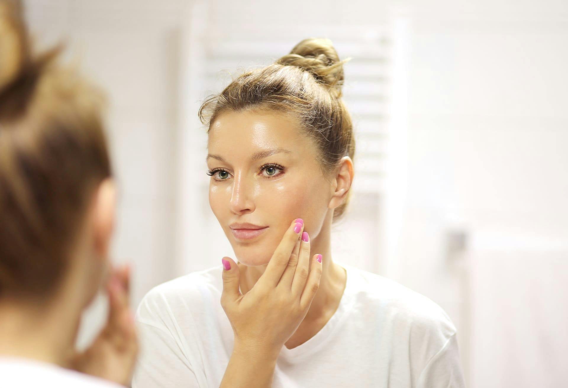 woman putting products on face