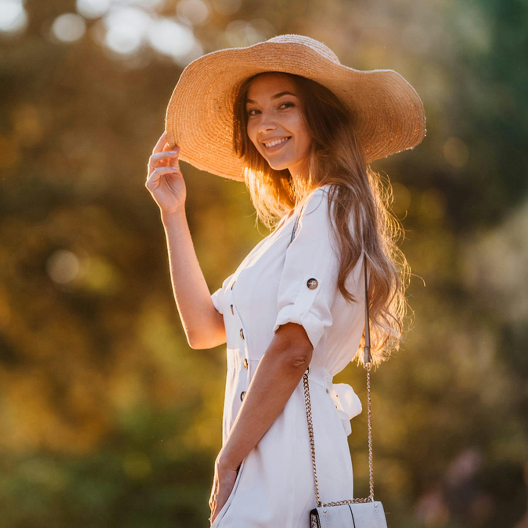 Woman in a white dress and oversized straw hat