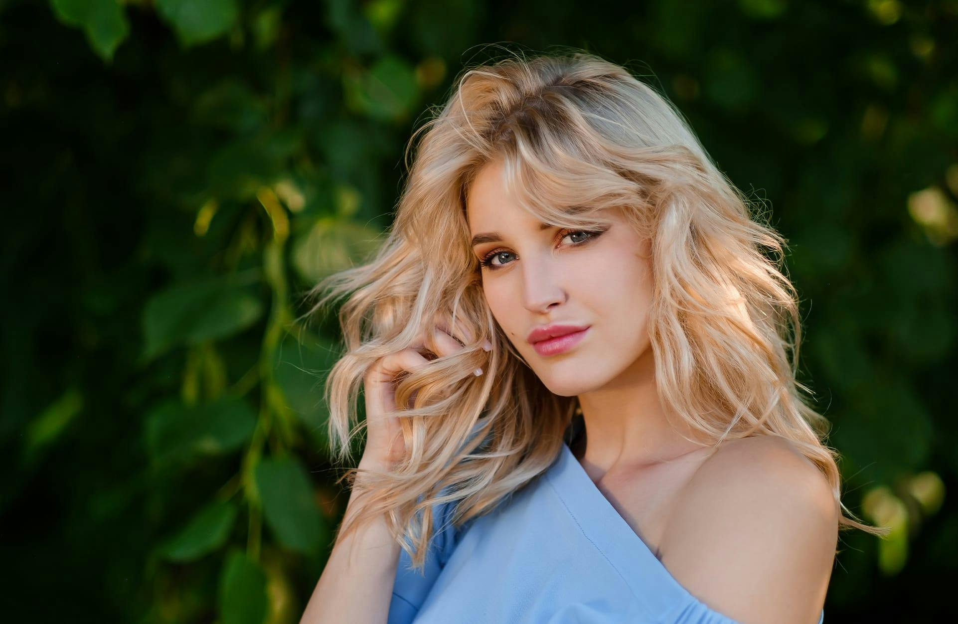 blonde woman in a blue top looking at the camera