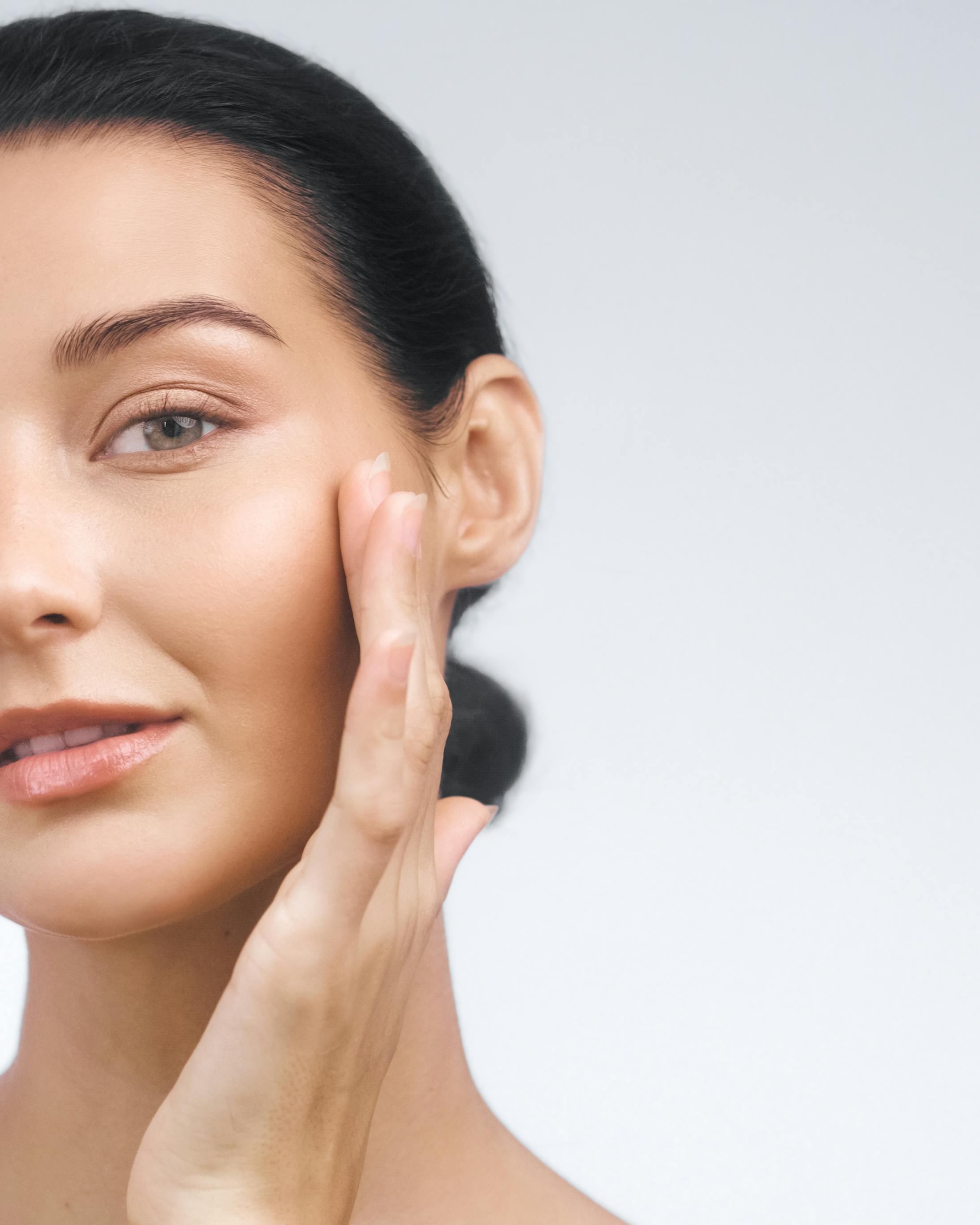 model with smooth skin placing hand on cheek