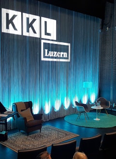 Bühne des Auditoriums im KKL Luzern mit Fadenvorhang und Stühlen für Lesung