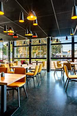 Tische und Hängesessel in der Deli Cafénbar Le Piaf im KKL Luzern mit Sicht auf den Europaplatz