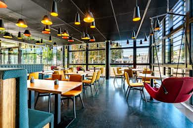 Tables and Hanging Chairs in the Deli Cafénbar Le Piaf in the KKL Lucerne with a View of the Europaplatz