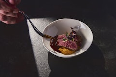 Koch tröpfelt Bratensauce über Roastbeef mit Polenta im KKL Luzern