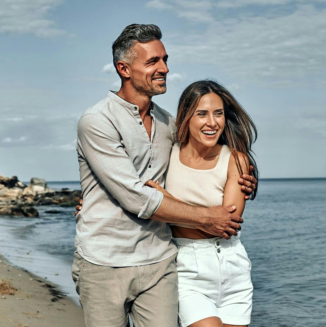 man and woman hugging on the beach