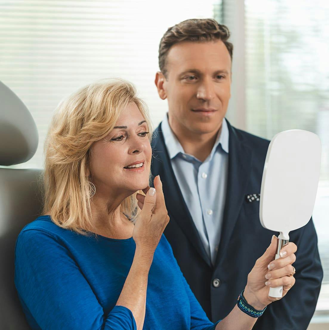 Dr. Farber with a patient who is looking in the mirror