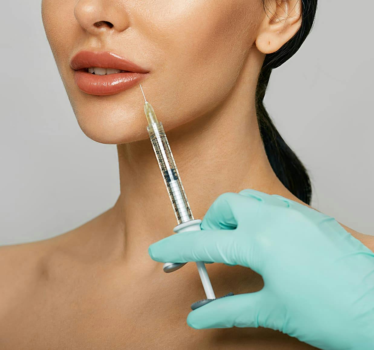 woman getting injection from a nurse in a blue glove