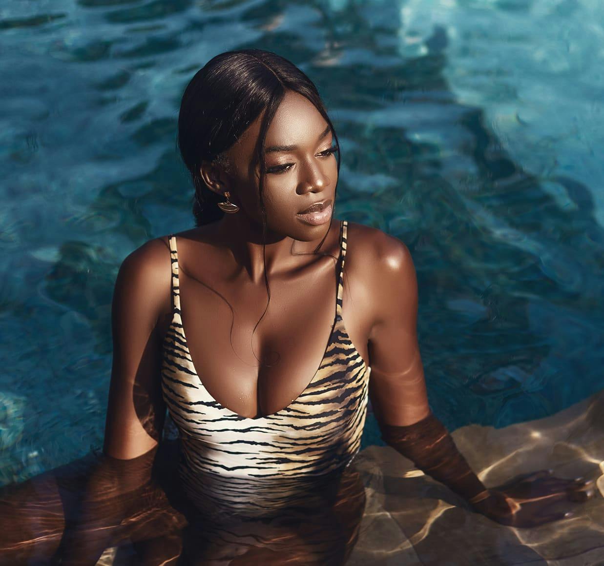 there is a woman in a tiger print swimsuit sitting in a pool
