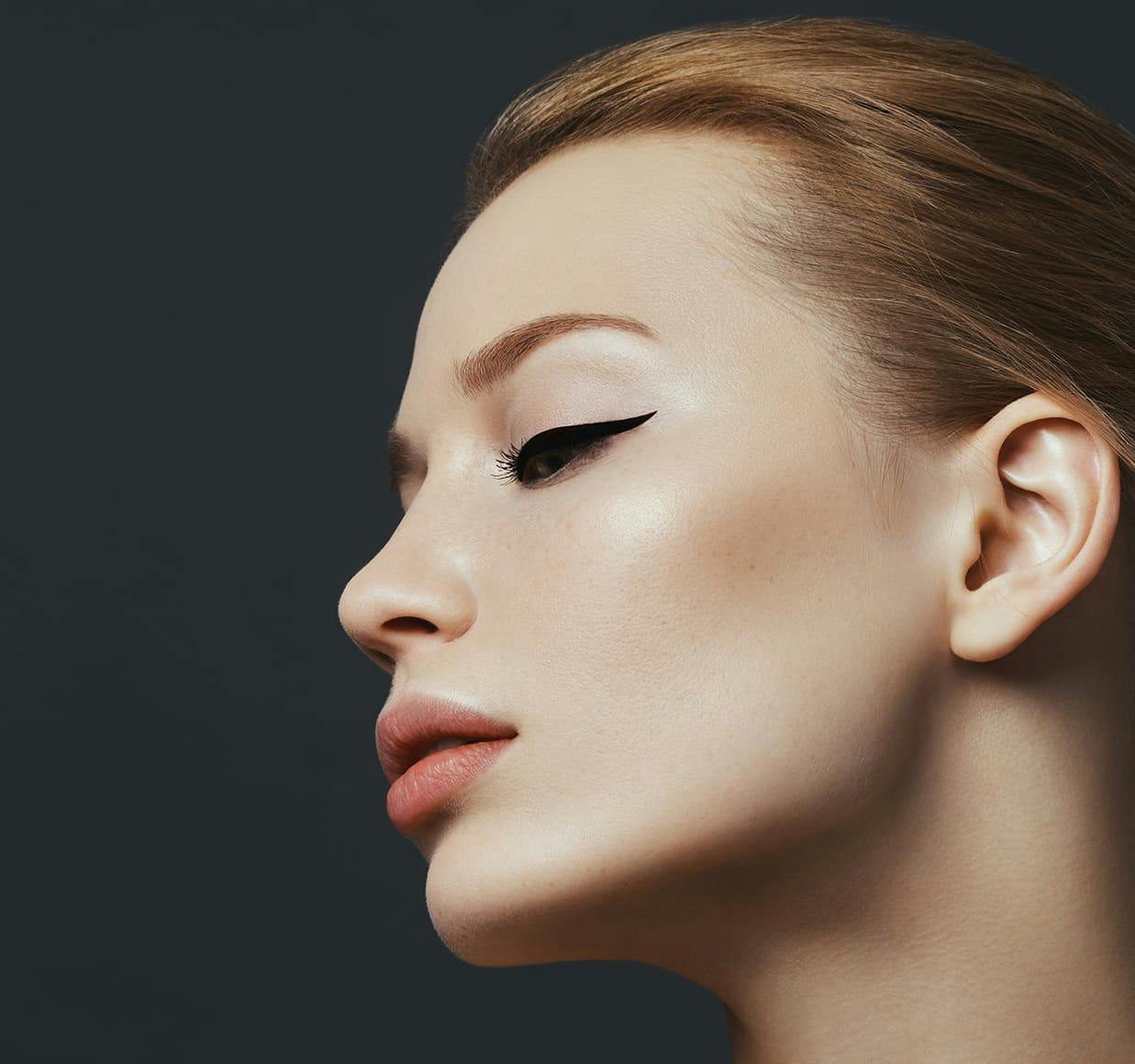blond woman with eyeliners and a black background
