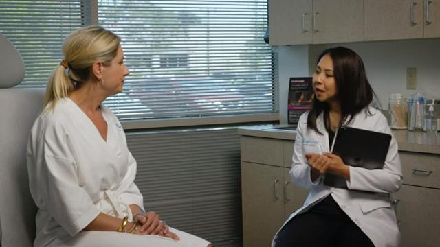 female doctor talking to a patient in a room with a window