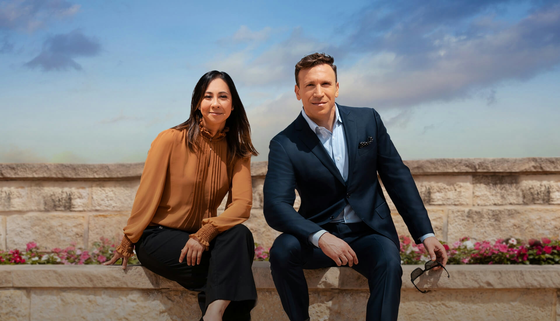 Dr. Shah and Farber sitting on a stone wall.