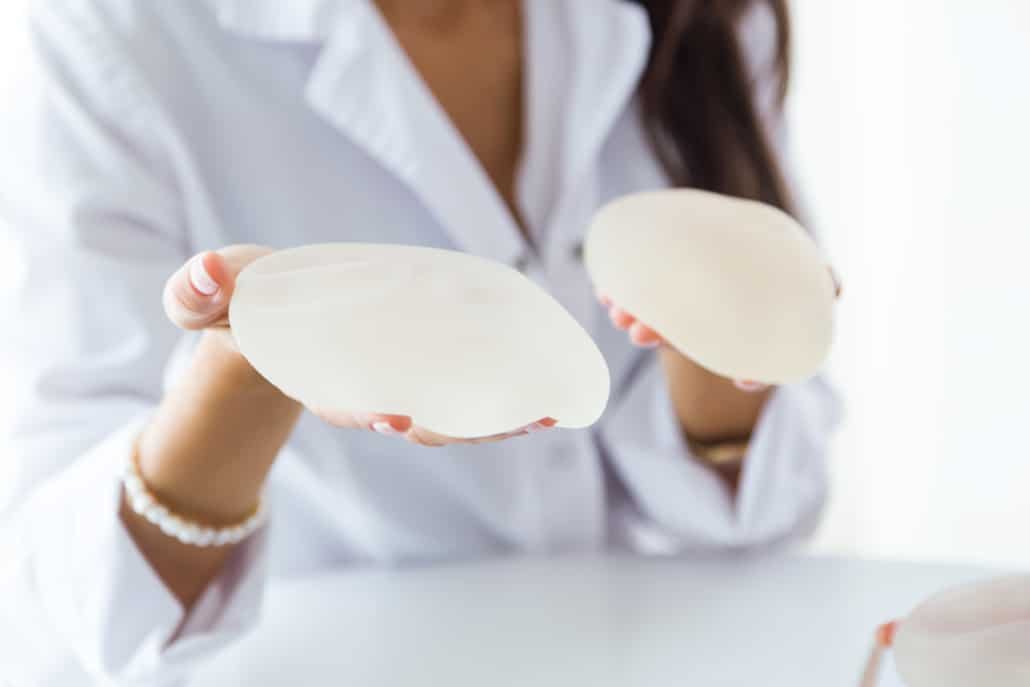 woman holding silicone implants