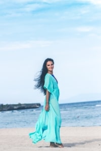 woman in a turqoise dress on the beach