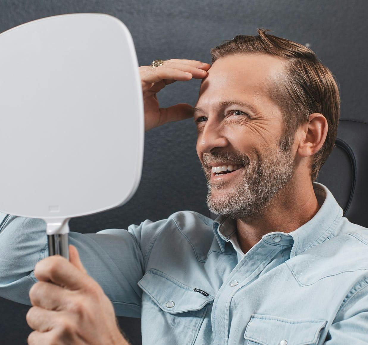 man smiling into a mirror