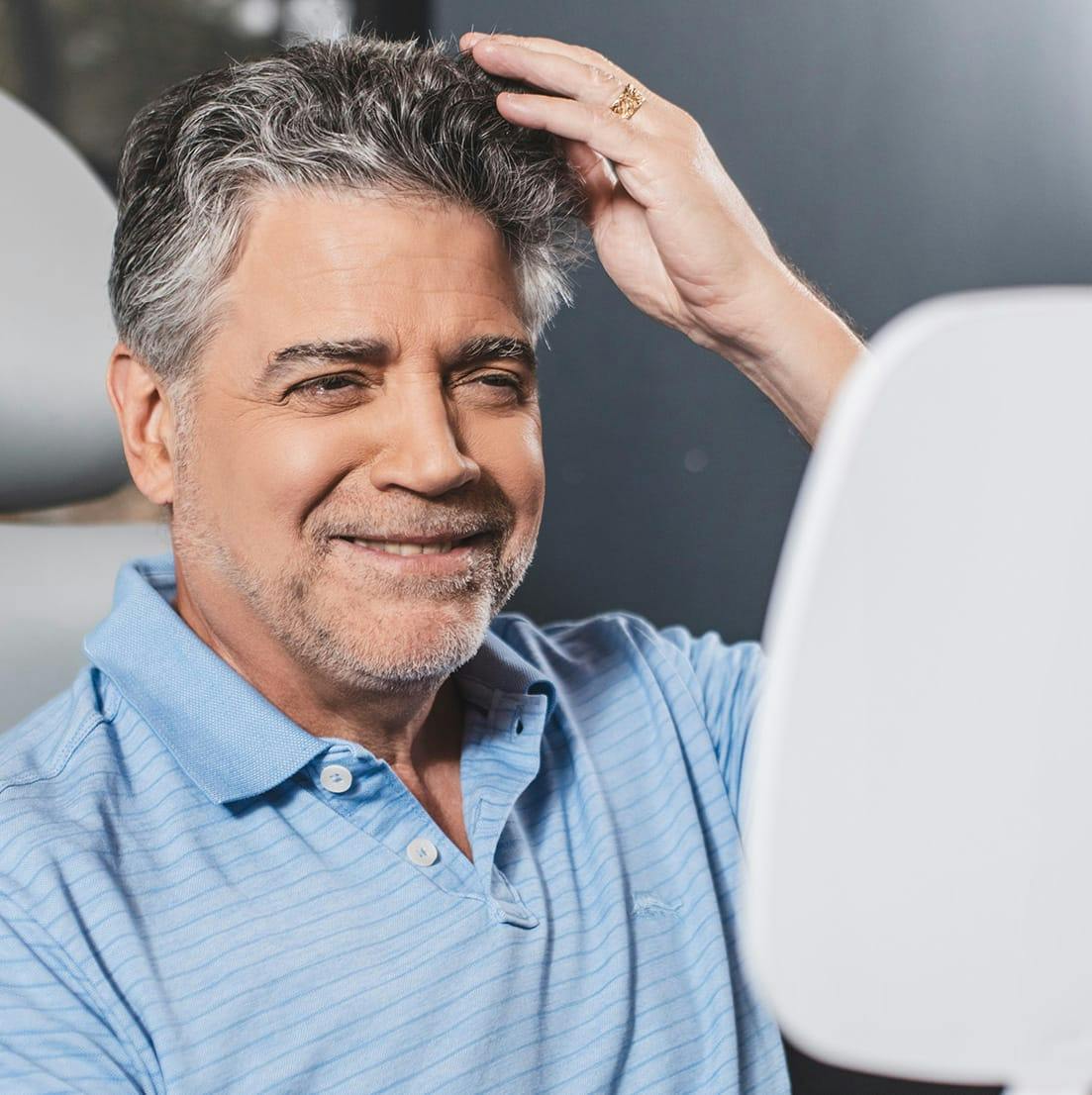 man looking at his hair