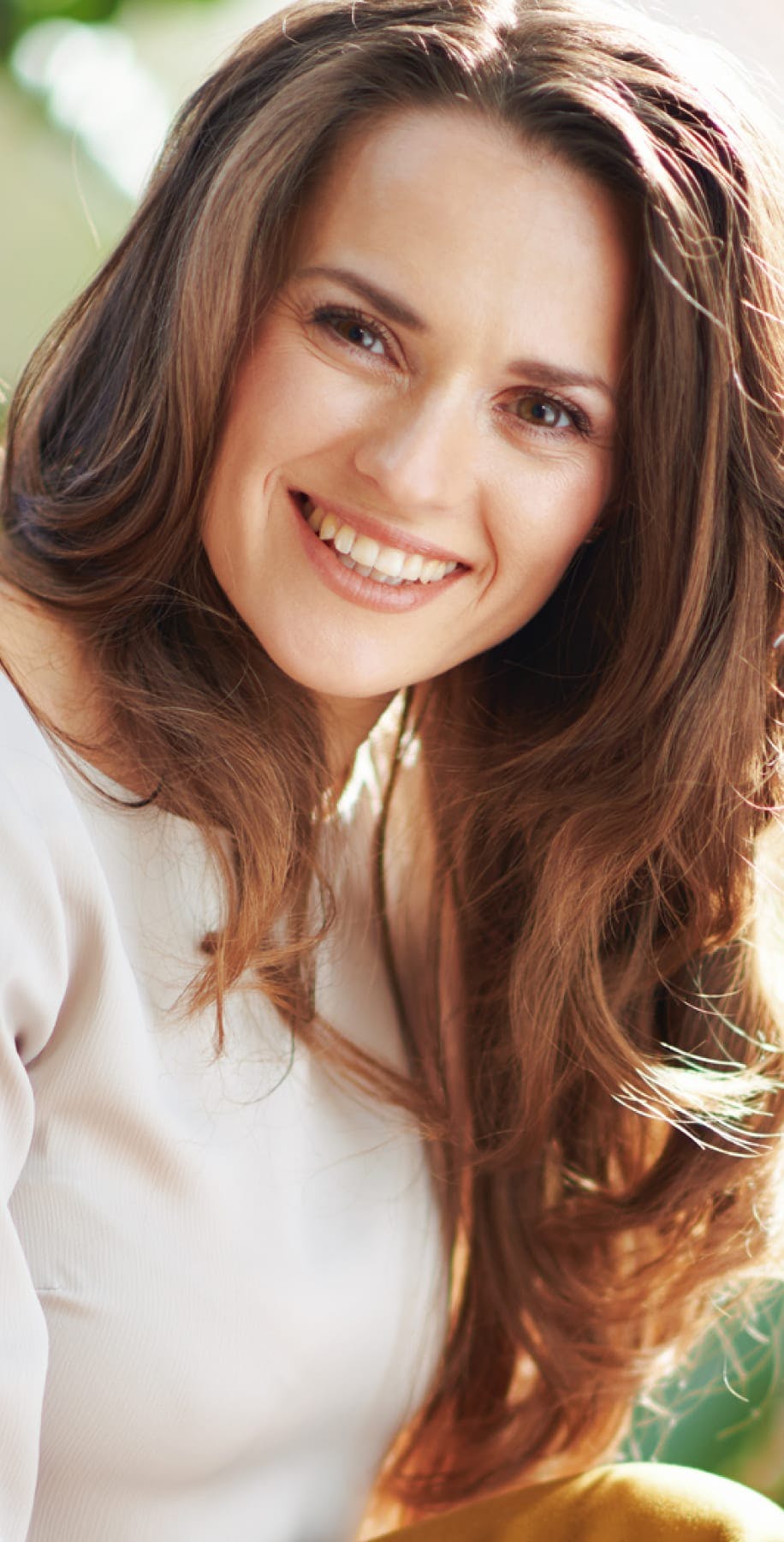 Woman with long curly auburn hair smiling