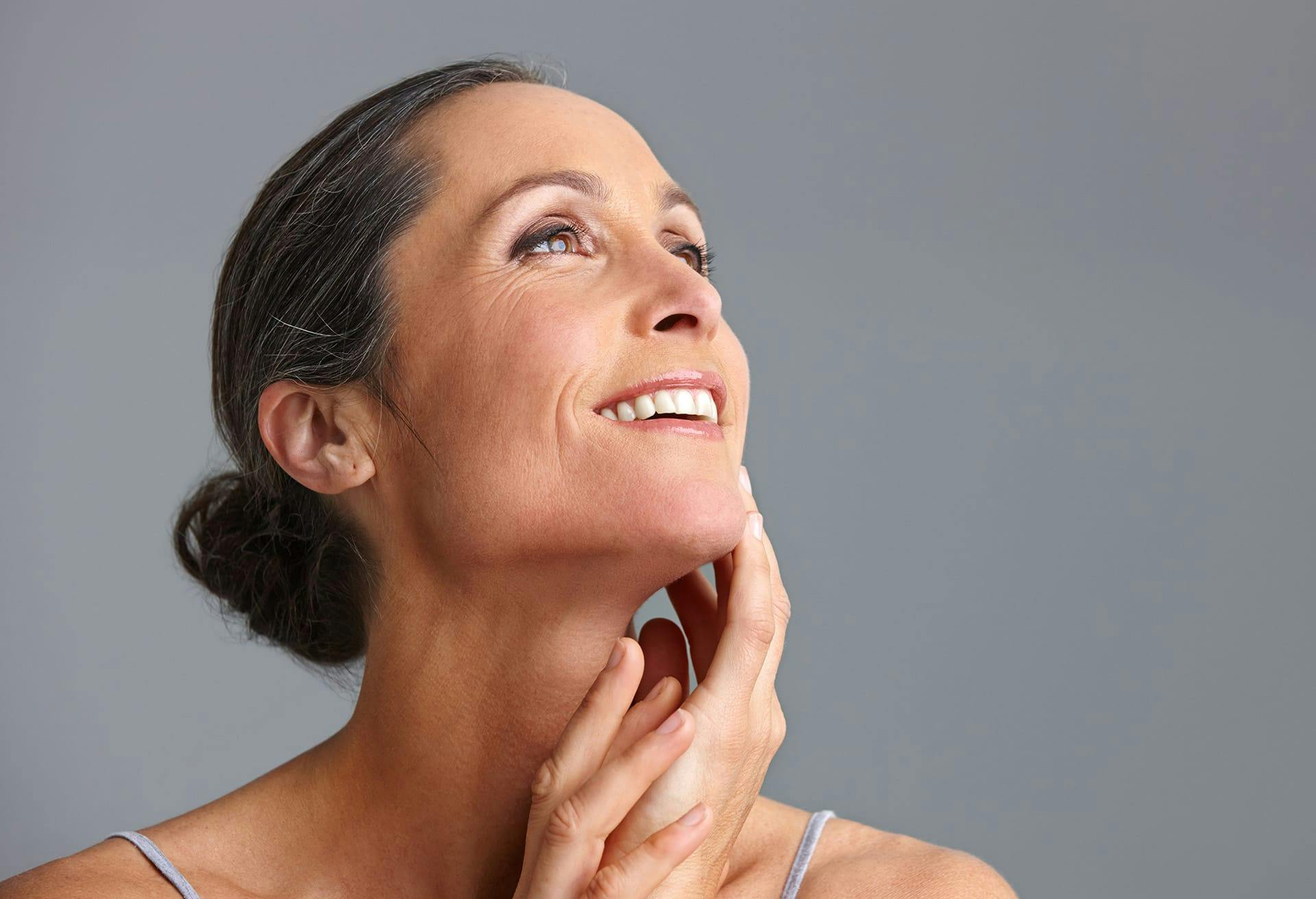 Woman looking up while touching her lower face
