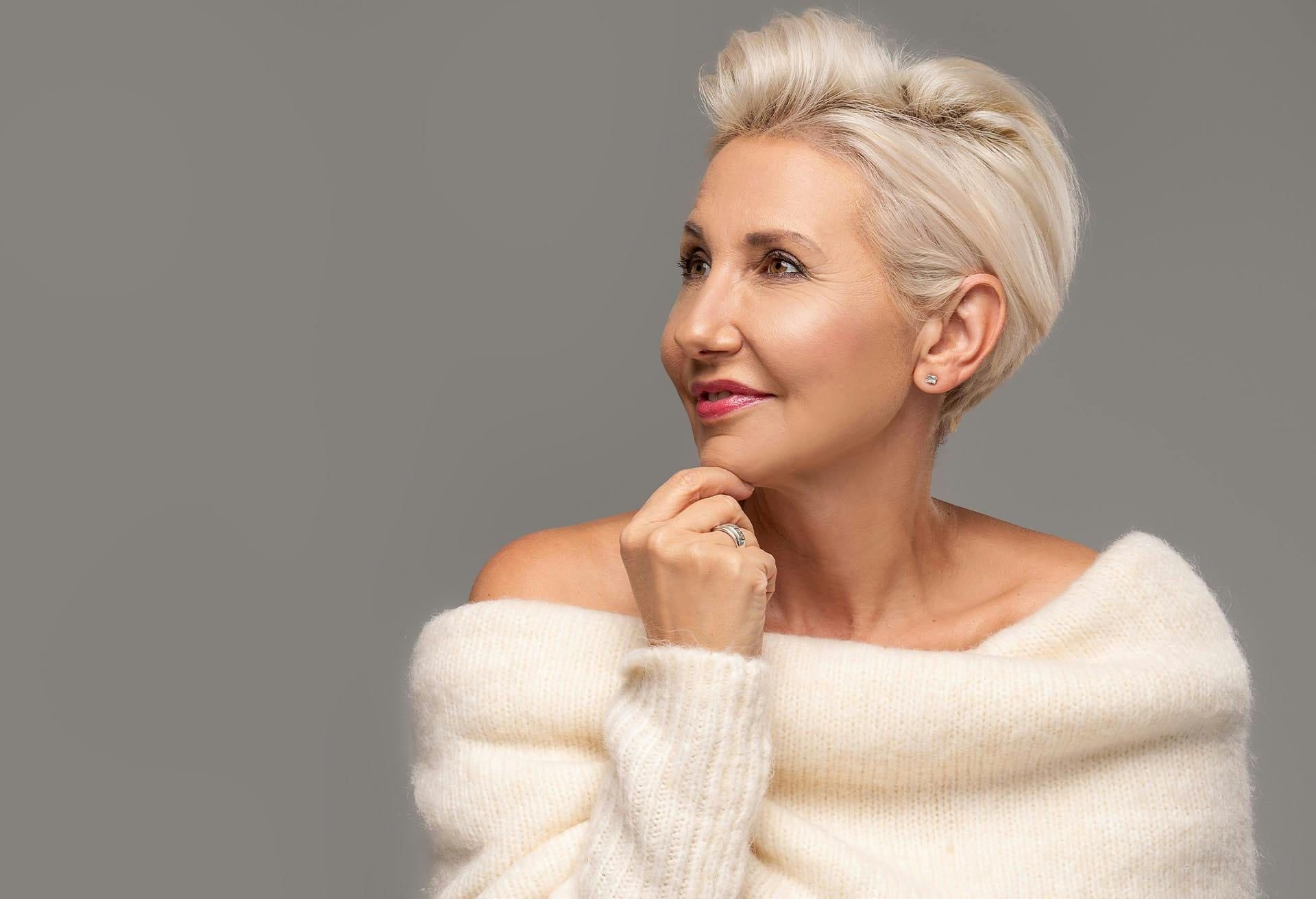 Beautiful middle aged woman wearing a white oversized sweater