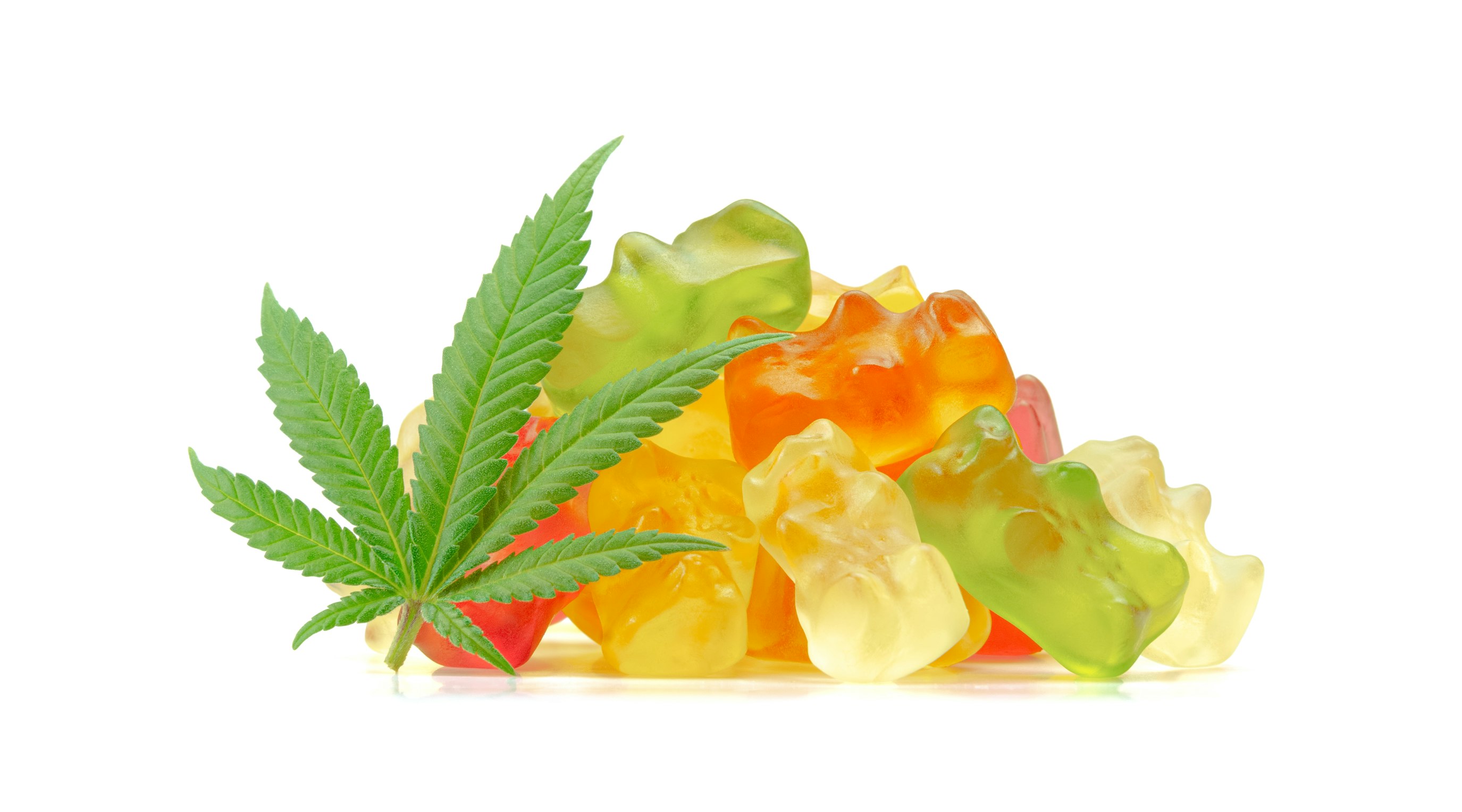 Pile of colorful gummy candies alongside a cannabis leaf, representing cannabis-infused gummies