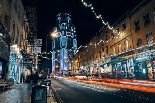 Night time view of Bristol's Park Street, with Wills Memorial Building lit up in the background.