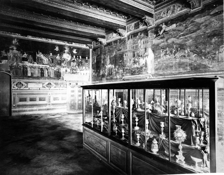 sala bianco e nero del museo civico di siena con vetrina con statutette