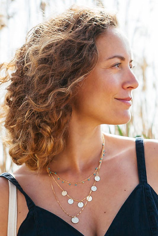 Woman smiling looking over to her left.