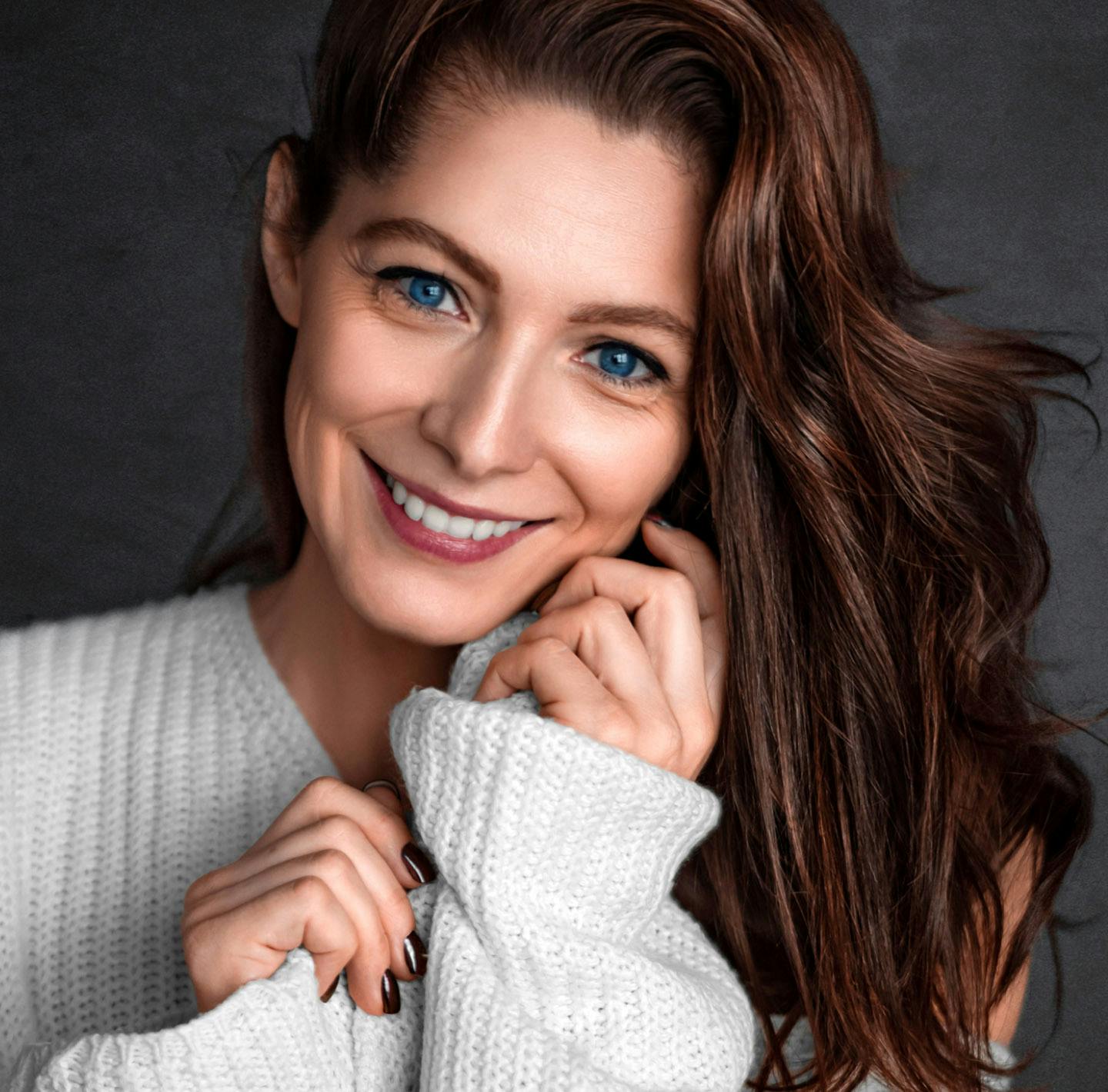 Close up with woman with long dark hair smiling.