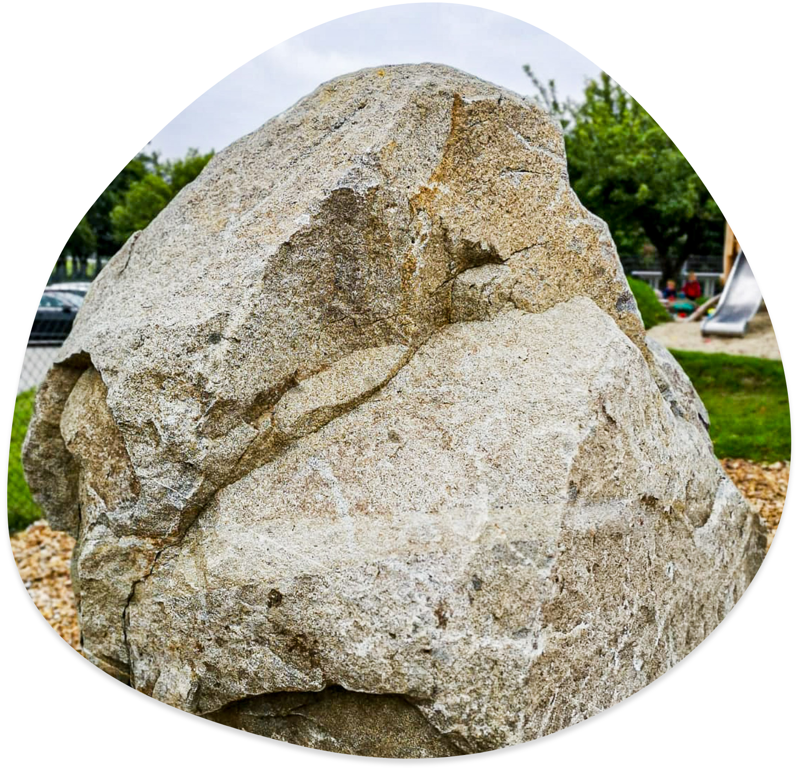 Großer Granitstein auf einem Spielplatz.