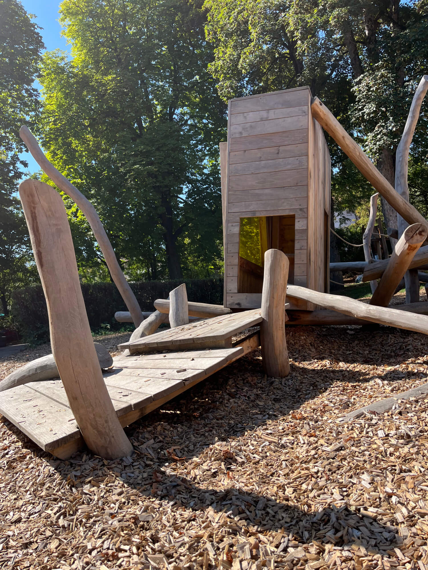 Eine hölzerne Spielstruktur in einem Waldgebiet.