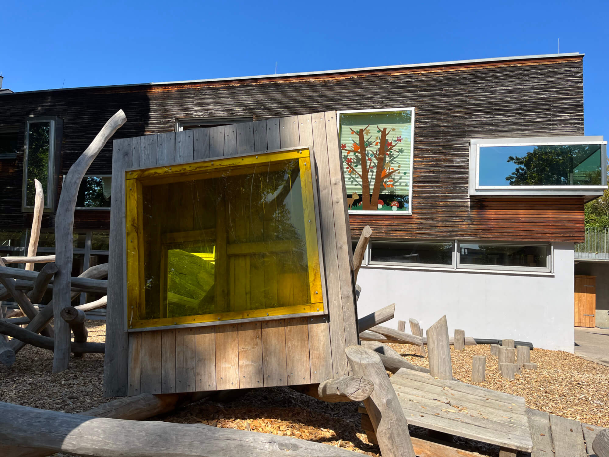 Eine Holzkonstruktion mit einem gelben Fenster.