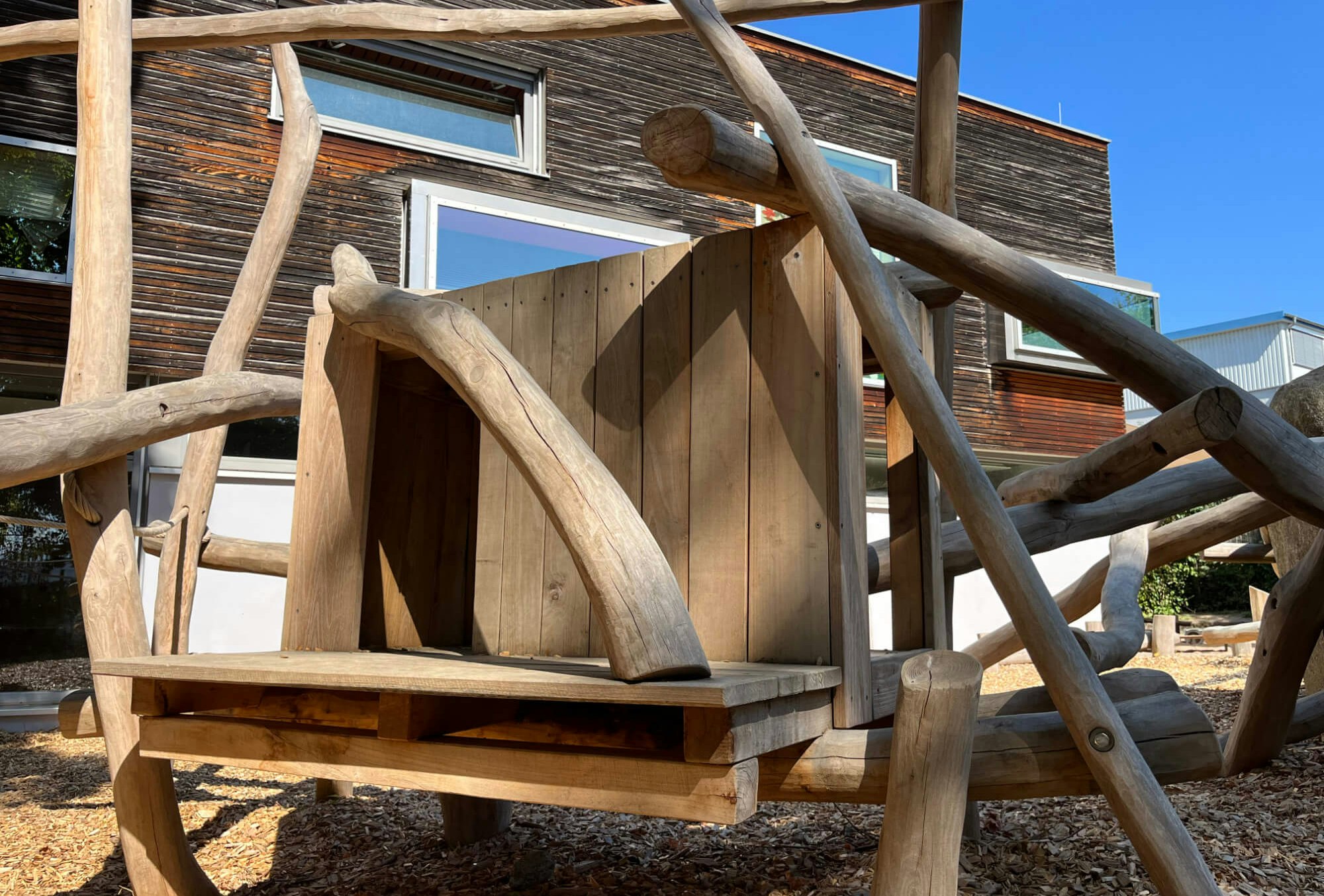 Eine Holzbank auf einem Spielplatz.