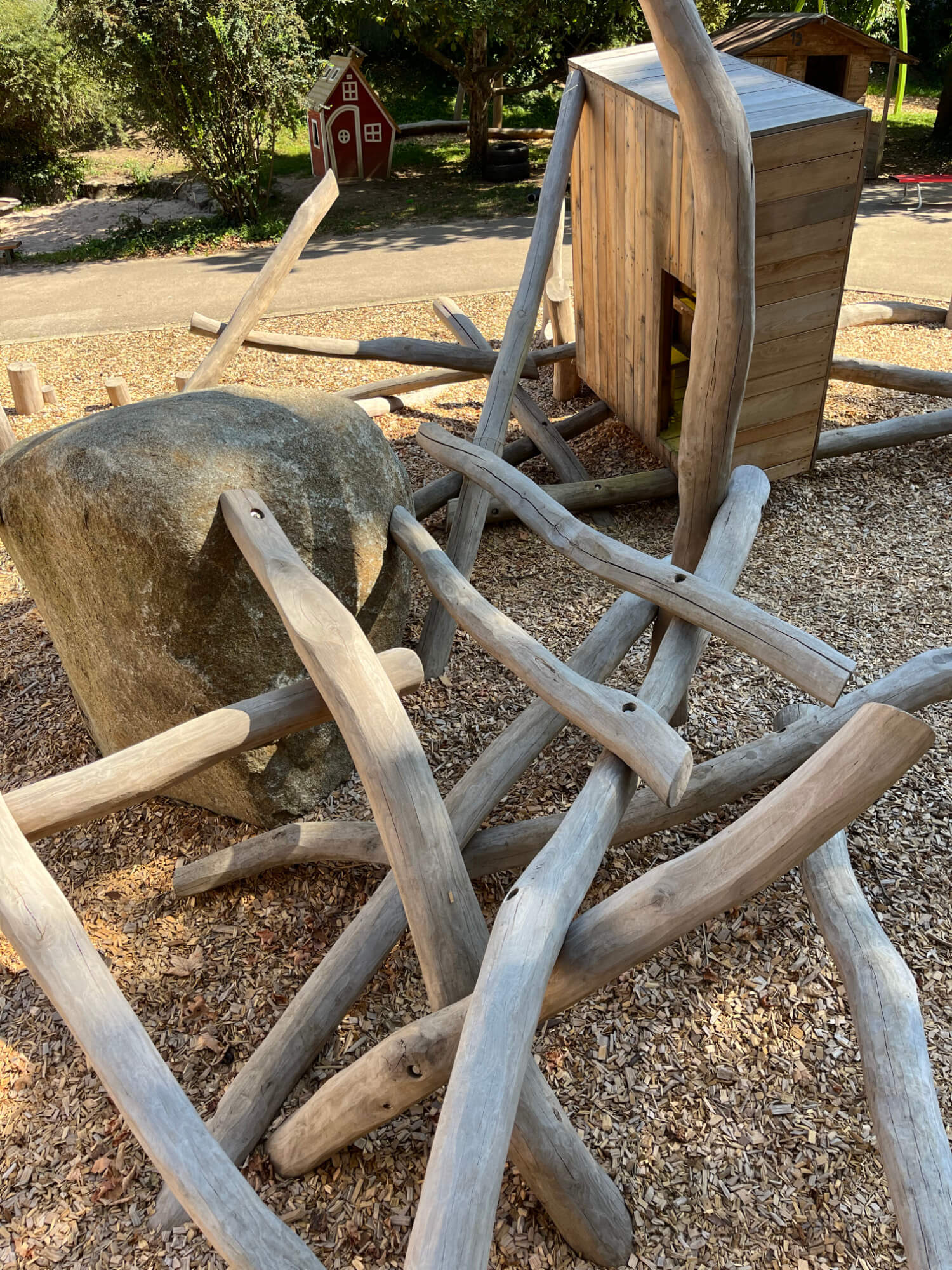 Eine hölzerne Spielstruktur aus Baumstämmen und Steinen.