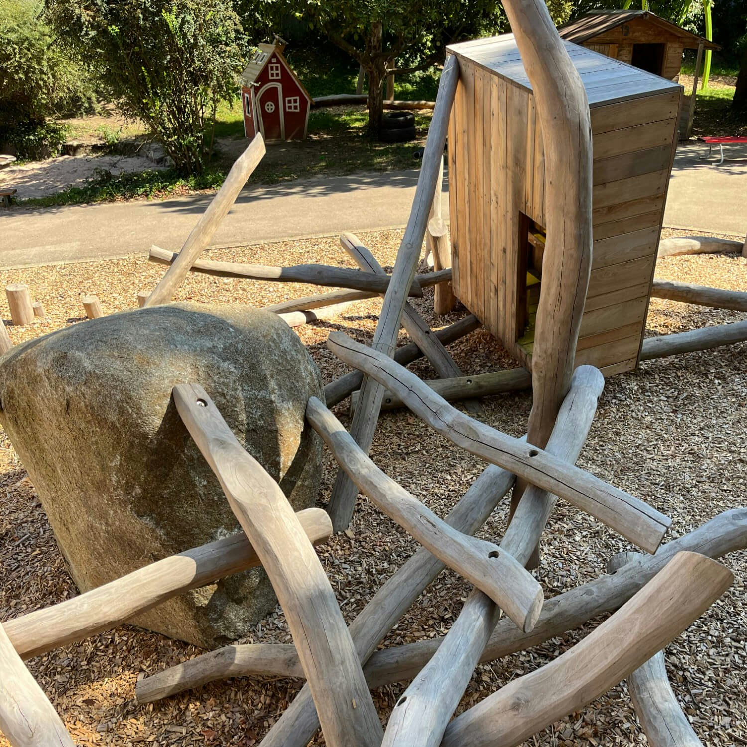 Eine hölzerne Spielstruktur aus Baumstämmen und Steinen.