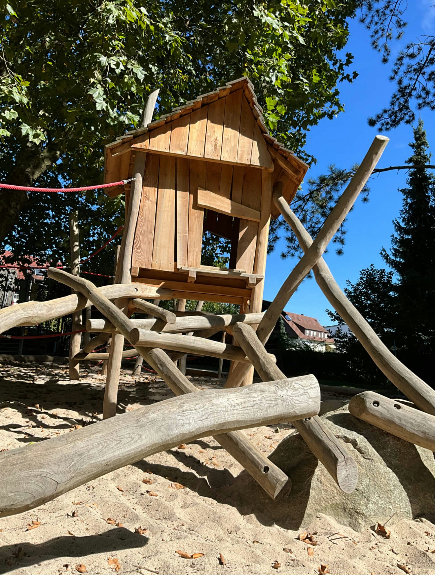 Eine hölzerne Spielstruktur im Sand.